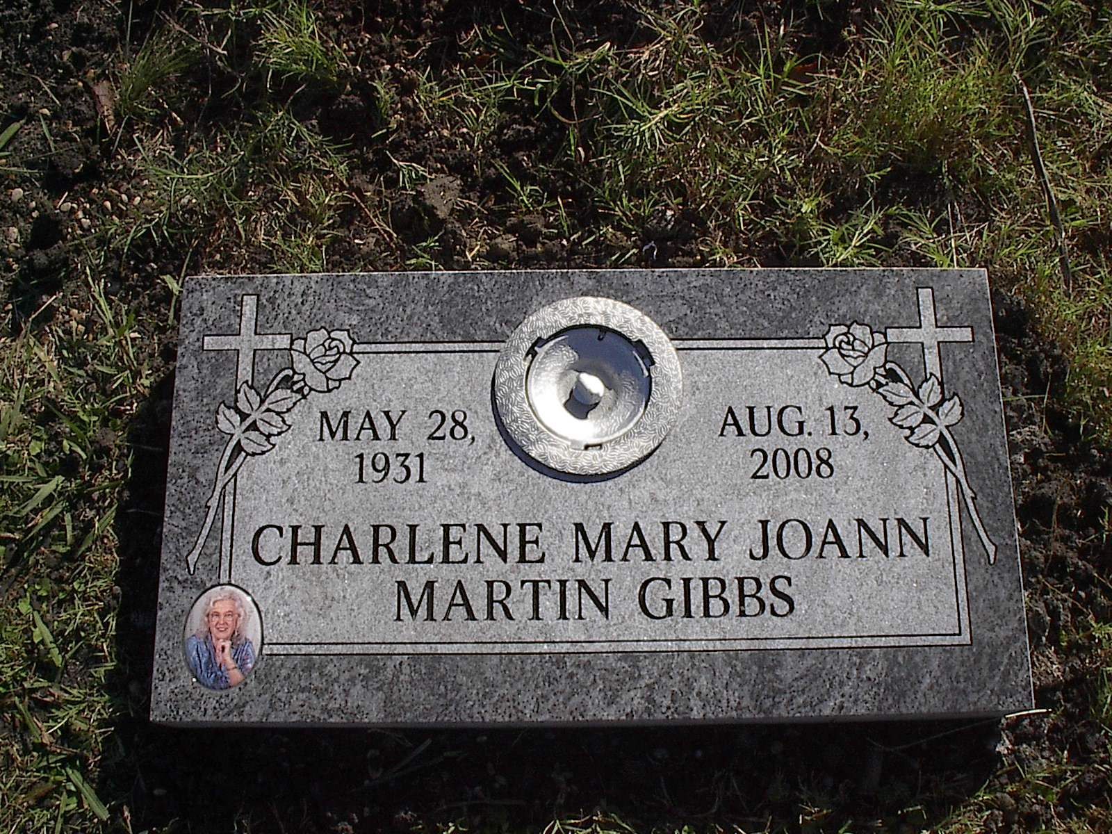 Gray headstone with engraved text, dates, name 