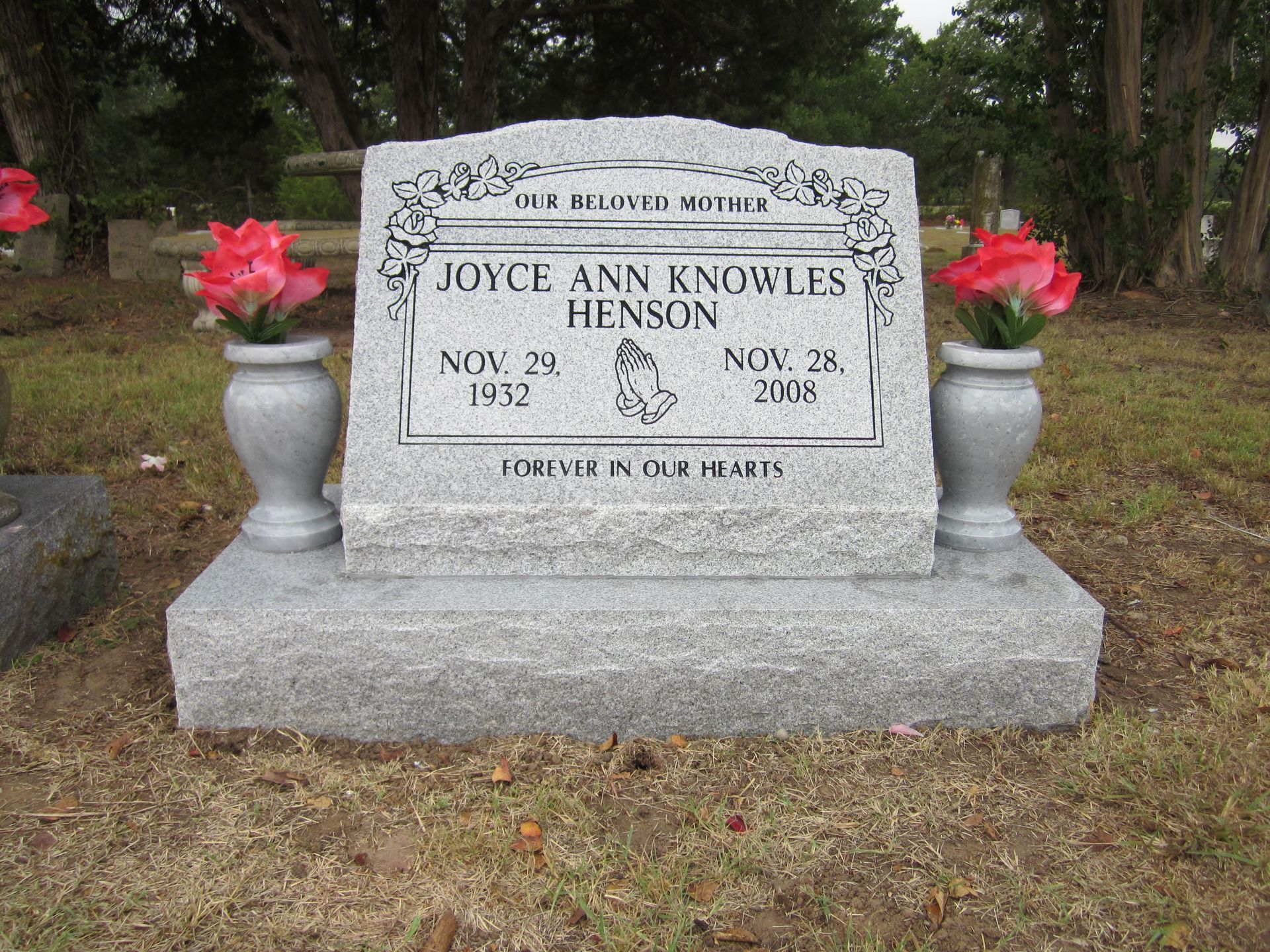 Headstone of Joyce Ann Knowles Henson (1932-2006). Two pink floral arrangements flank the stone.