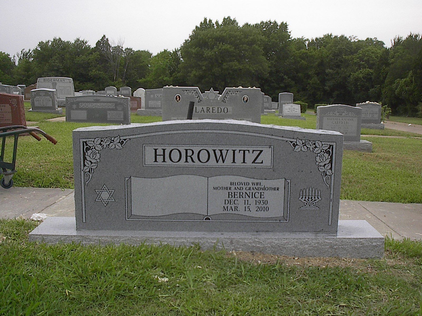 Gray headstone in a cemetery, with the name