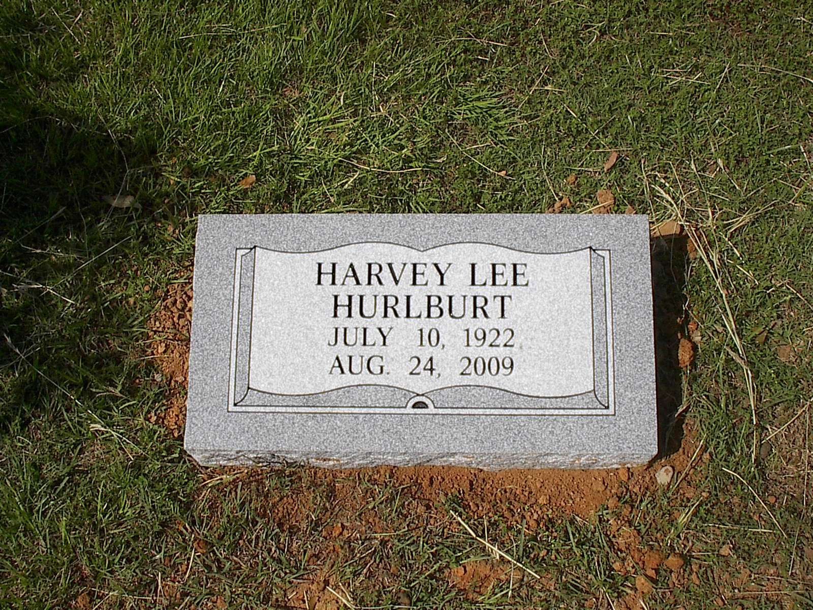 Grave marker for Harvey Lee Hurlburt. Gray stone, inscribed with name, birth, and death dates; set in grass.