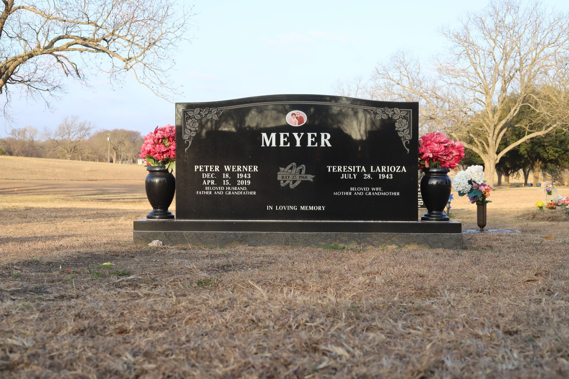 Black granite headstone in a cemetery; bears the last name
