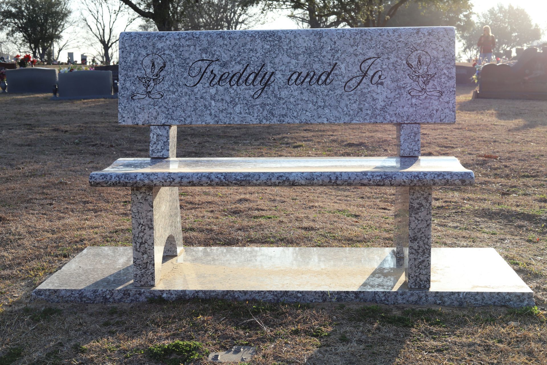 Granite bench in a cemetery; inscribed with 