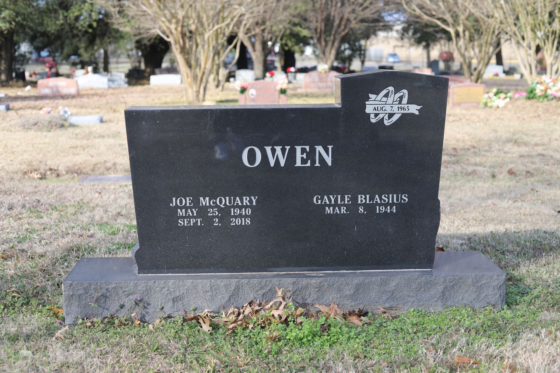 Black granite headstone in a cemetery; reads