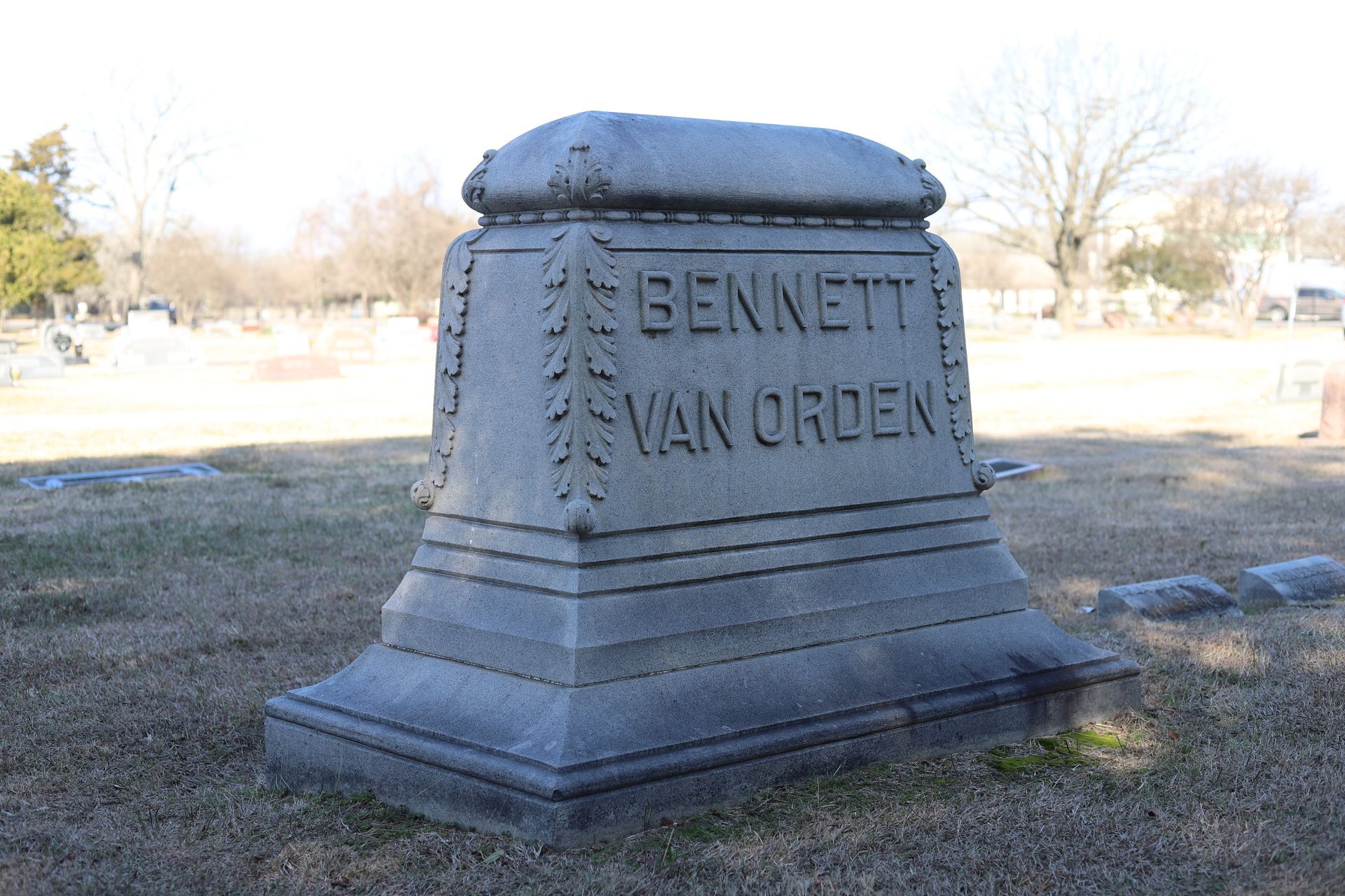 Gray stone tombstone in a cemetery; name 