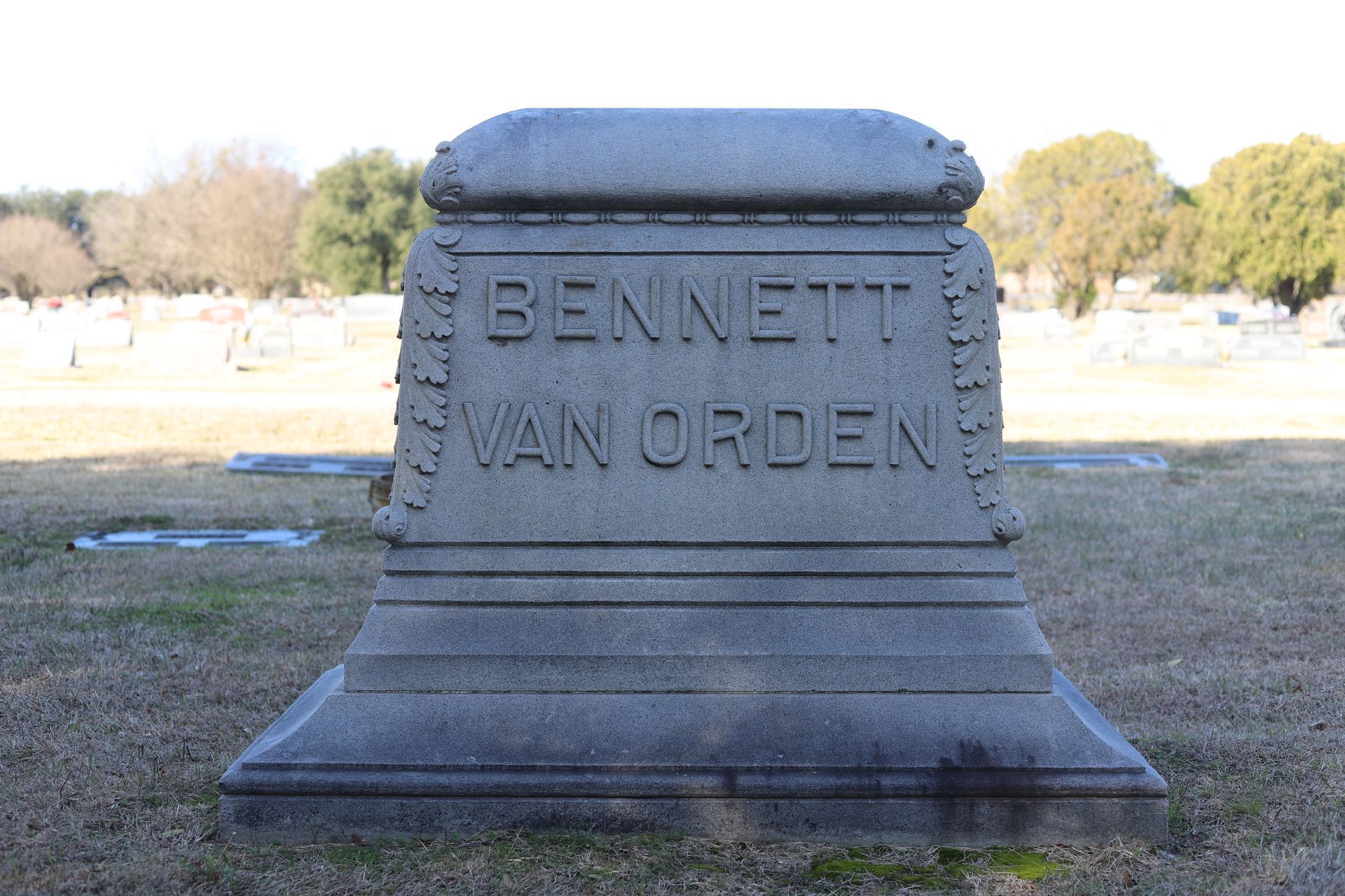 Gray stone tombstone in a cemetery; name 