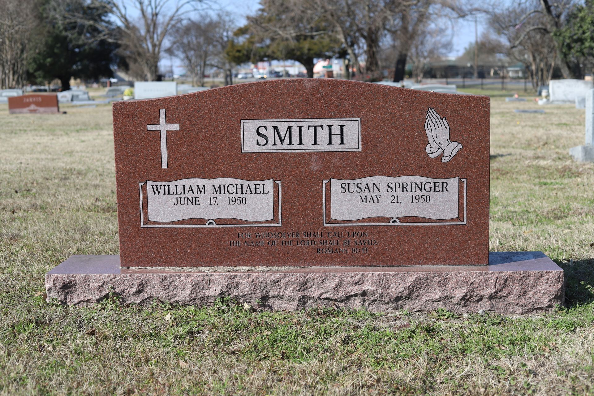 Red granite headstone in a cemetery; reads