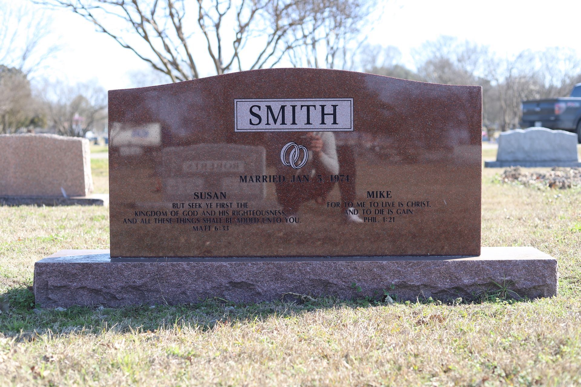 Headstone for the Smith family in a cemetery; red-brown granite, engraved with names and dates.