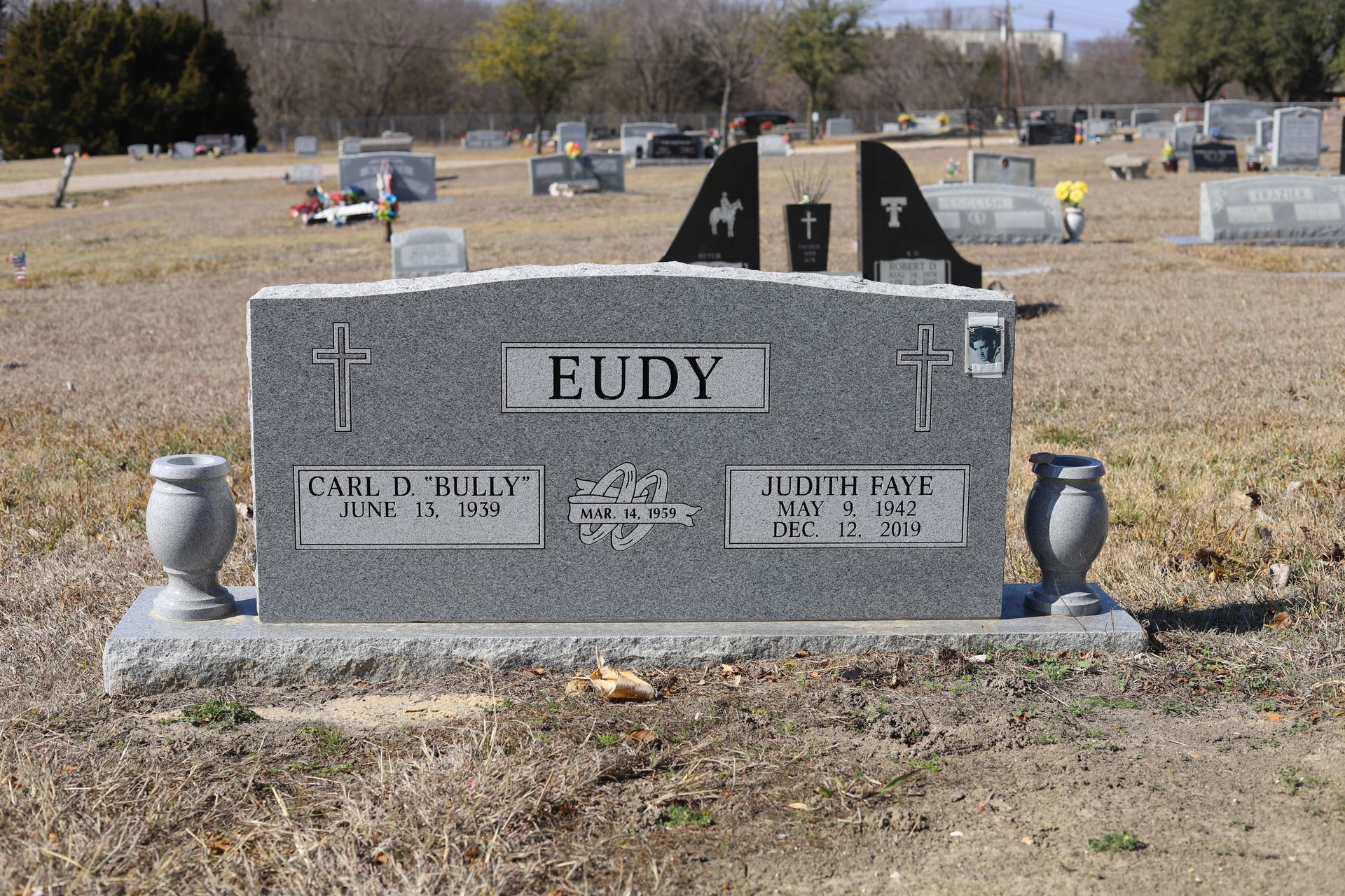 Gray granite headstone in a cemetery with the name