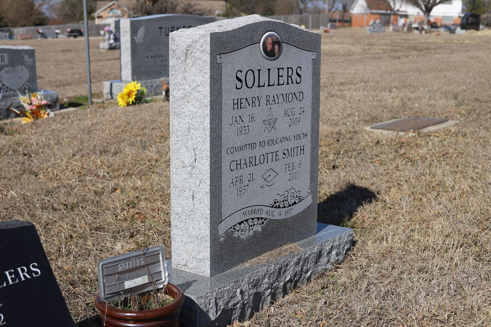 Grave marker in a cemetery with a photo and the name