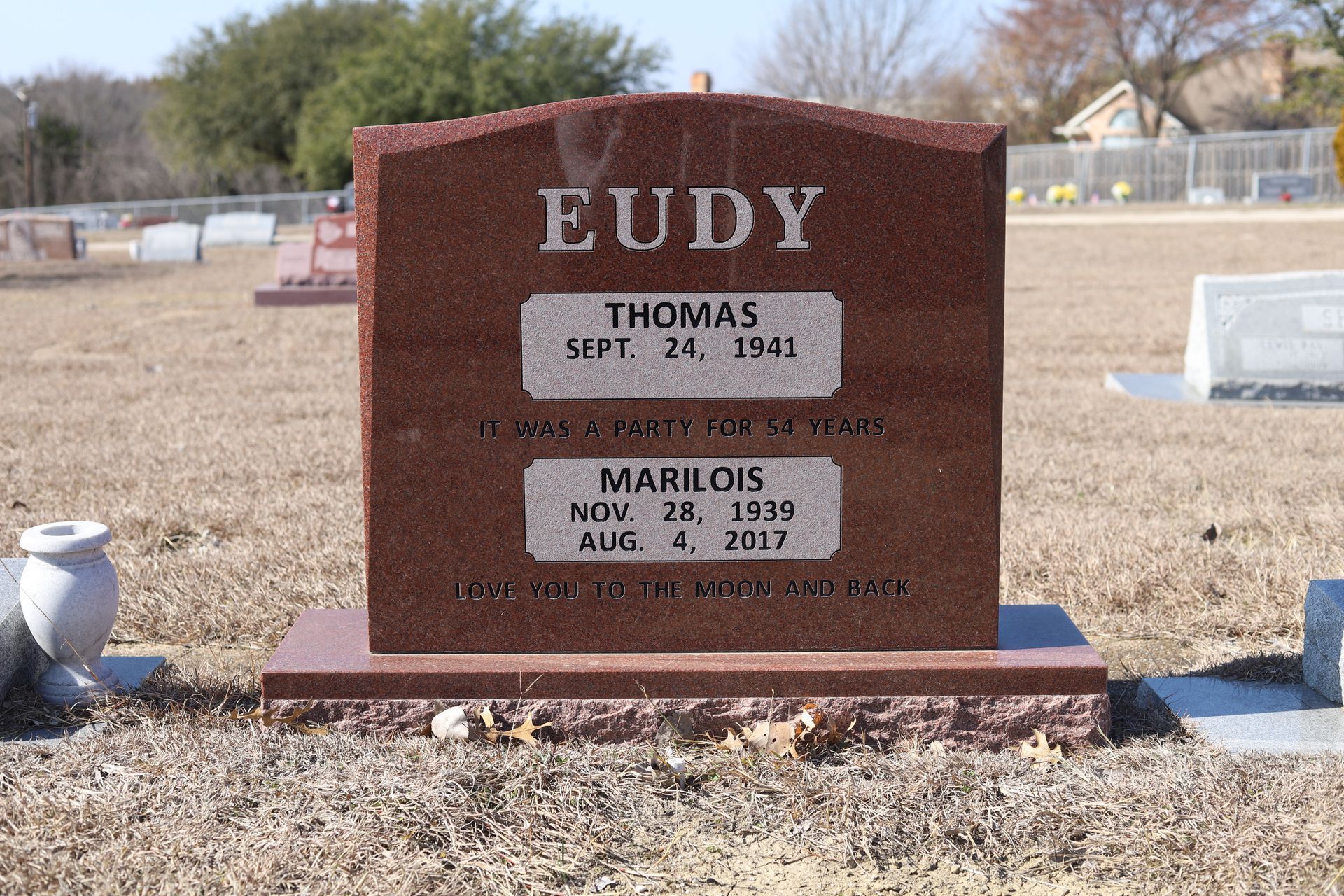 Red granite headstone in a cemetery; reads 