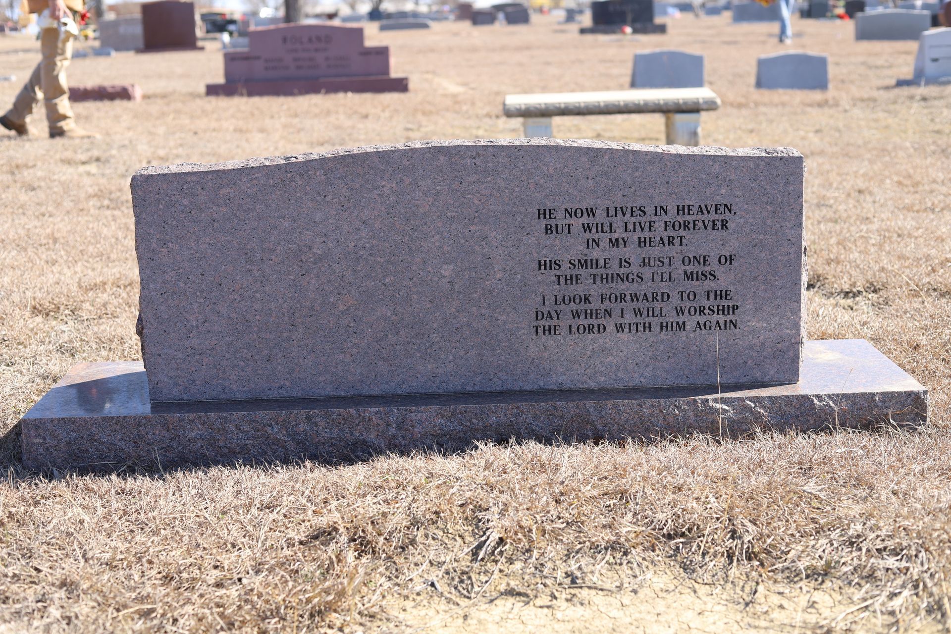 Granite tombstone in a cemetery; inscription reads,