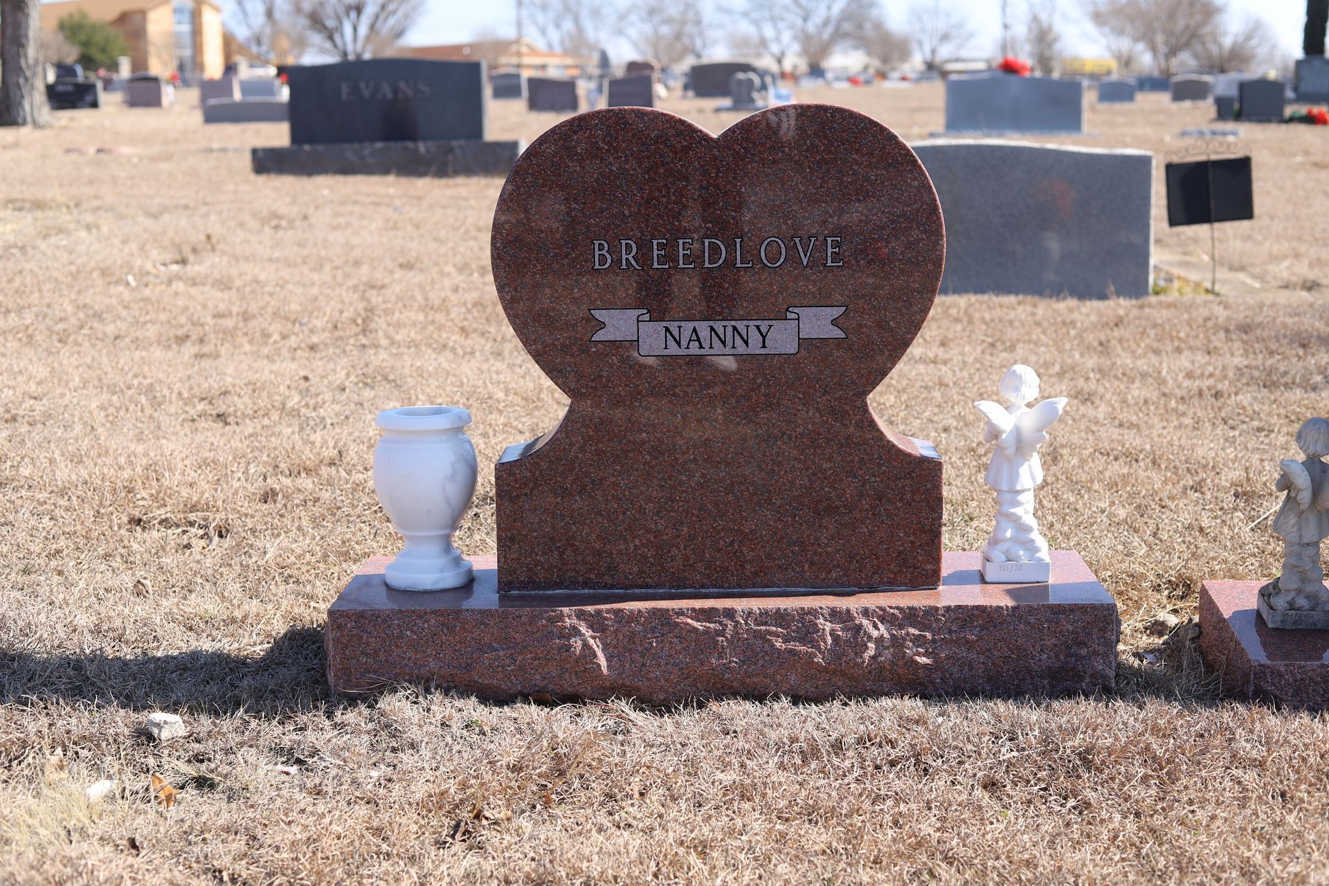 Heart-shaped red granite headstone in a cemetery; 
