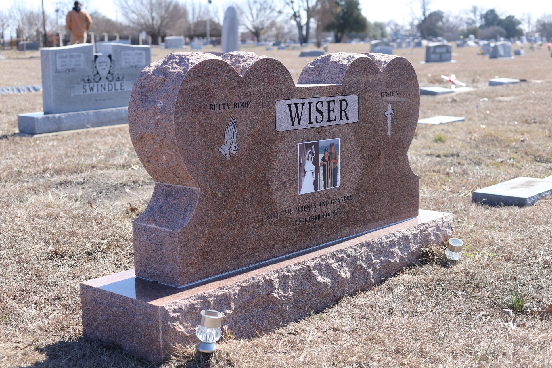 Pink granite headstone in a cemetery; name 