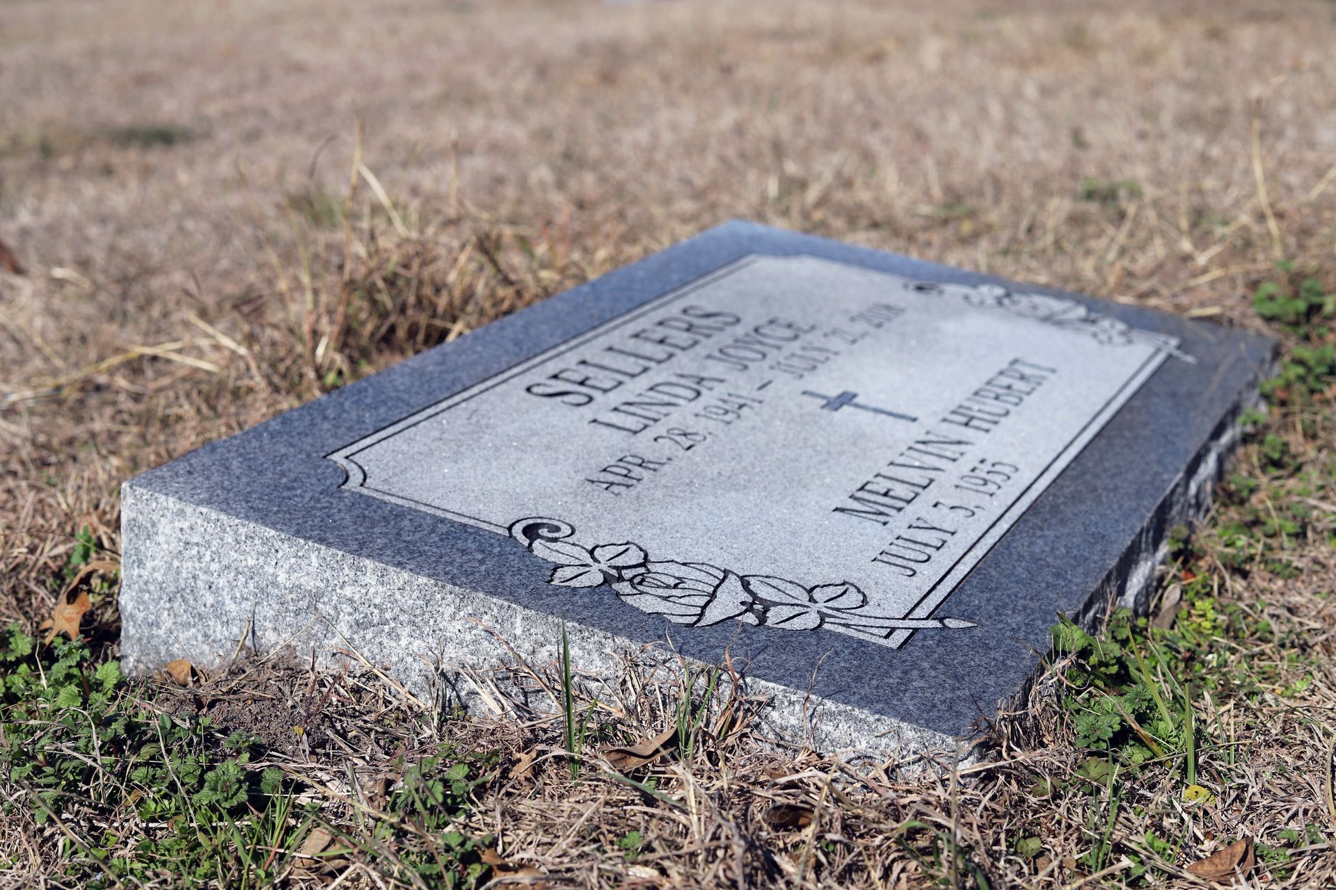 Gravestone of Linda Morse Sellers and Melvin Herbert, lying on grass.