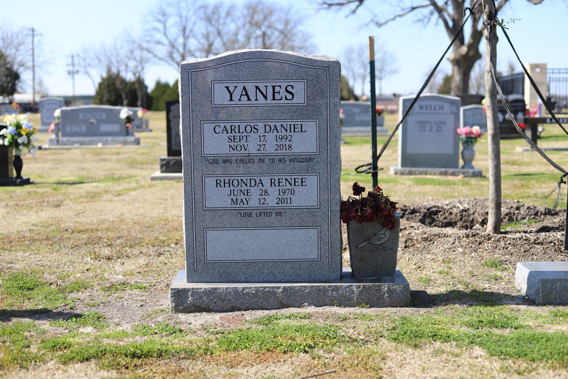 Gray headstone in a cemetery with the name