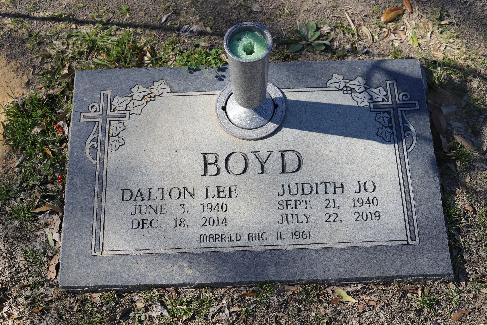 Headstone for Dalton Lee Boyd (1940-2014) and Judith Jo Boyd (1943-2013). Gray stone with a flower vase.