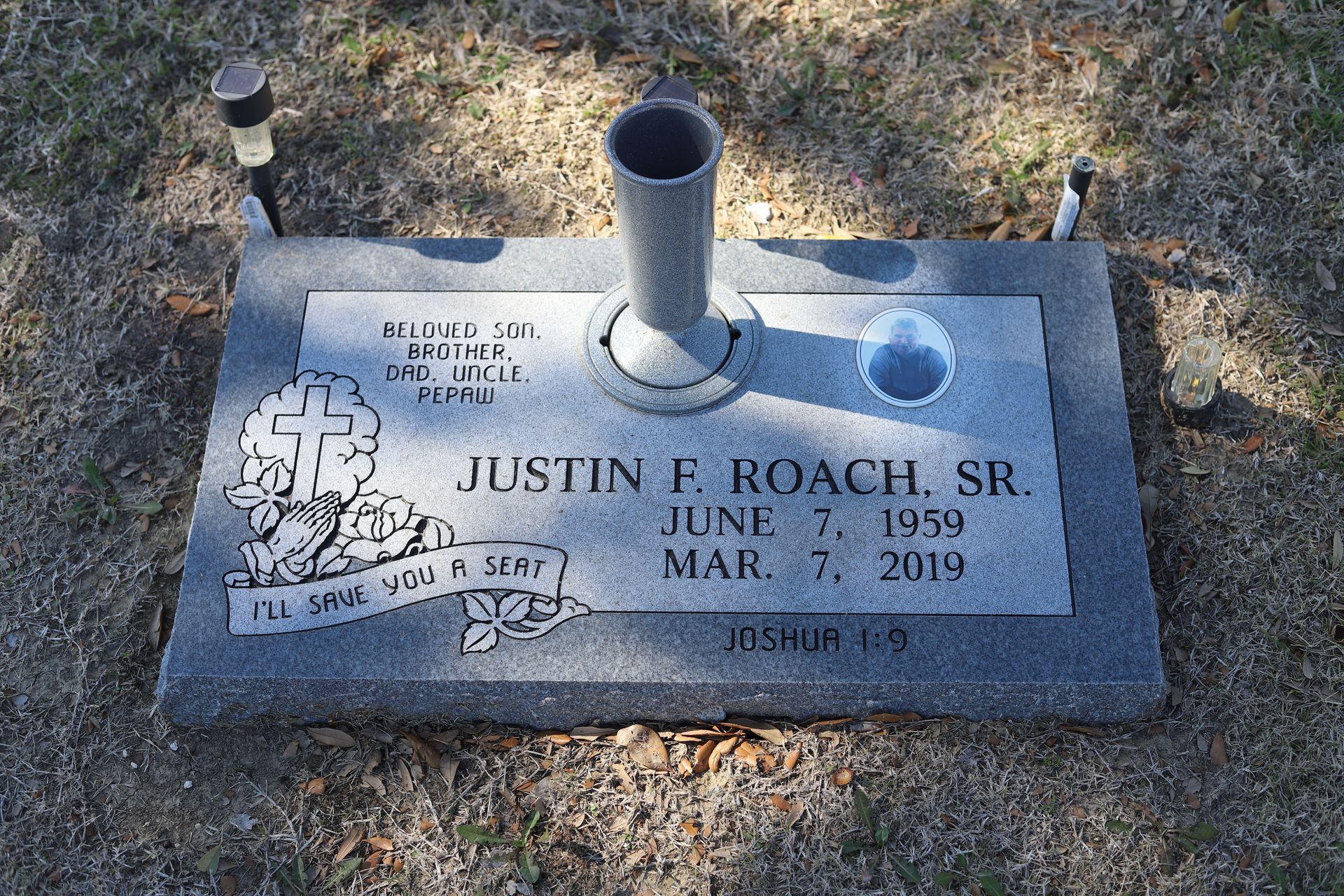 Gravestone of Justin F. Roach, Sr., with birth and death dates, a vase, and a Bible verse.