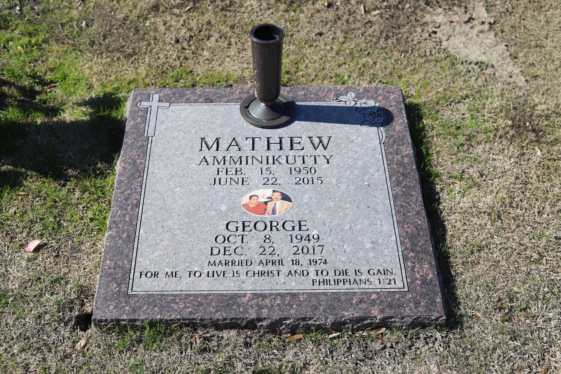 Tombstone with names MATHEW AMMINIKUTTY and GEORGE; dates of birth/death, with a vase.