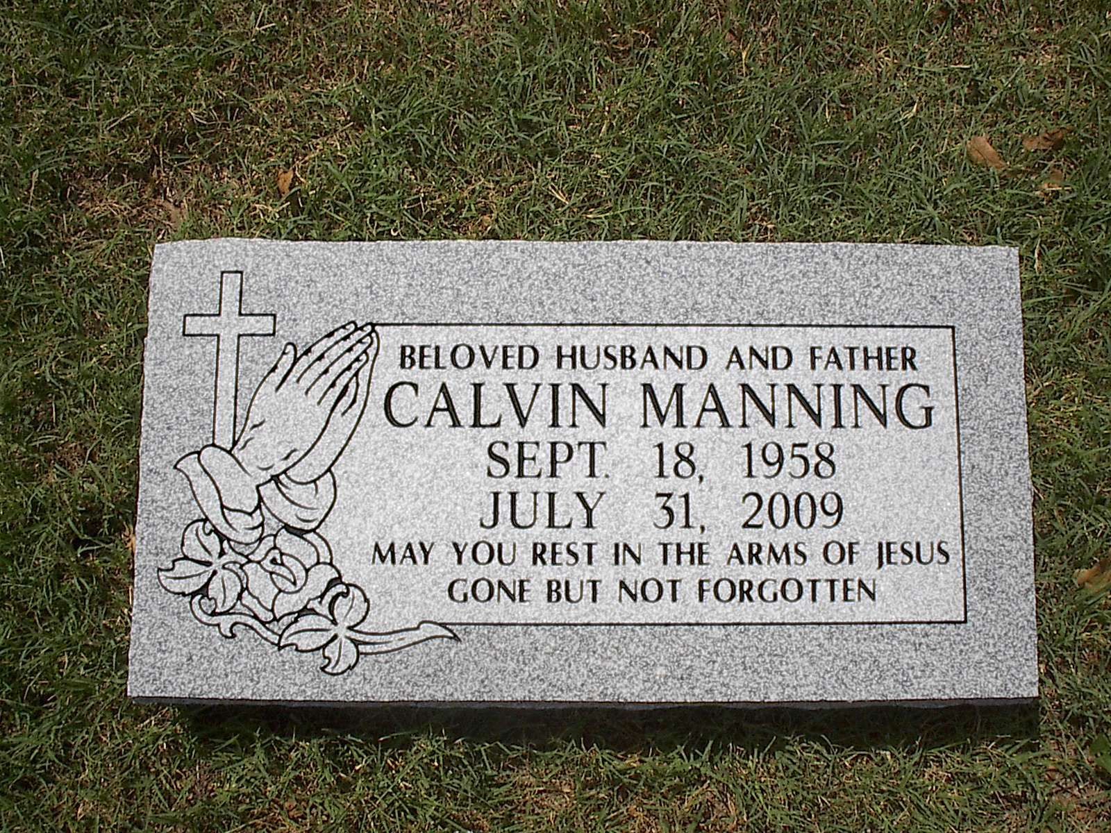 Tombstone of Calvin Manning: dates Sept. 18, 1958 - July 31, 2009. Includes a cross, praying hands, and flowers.