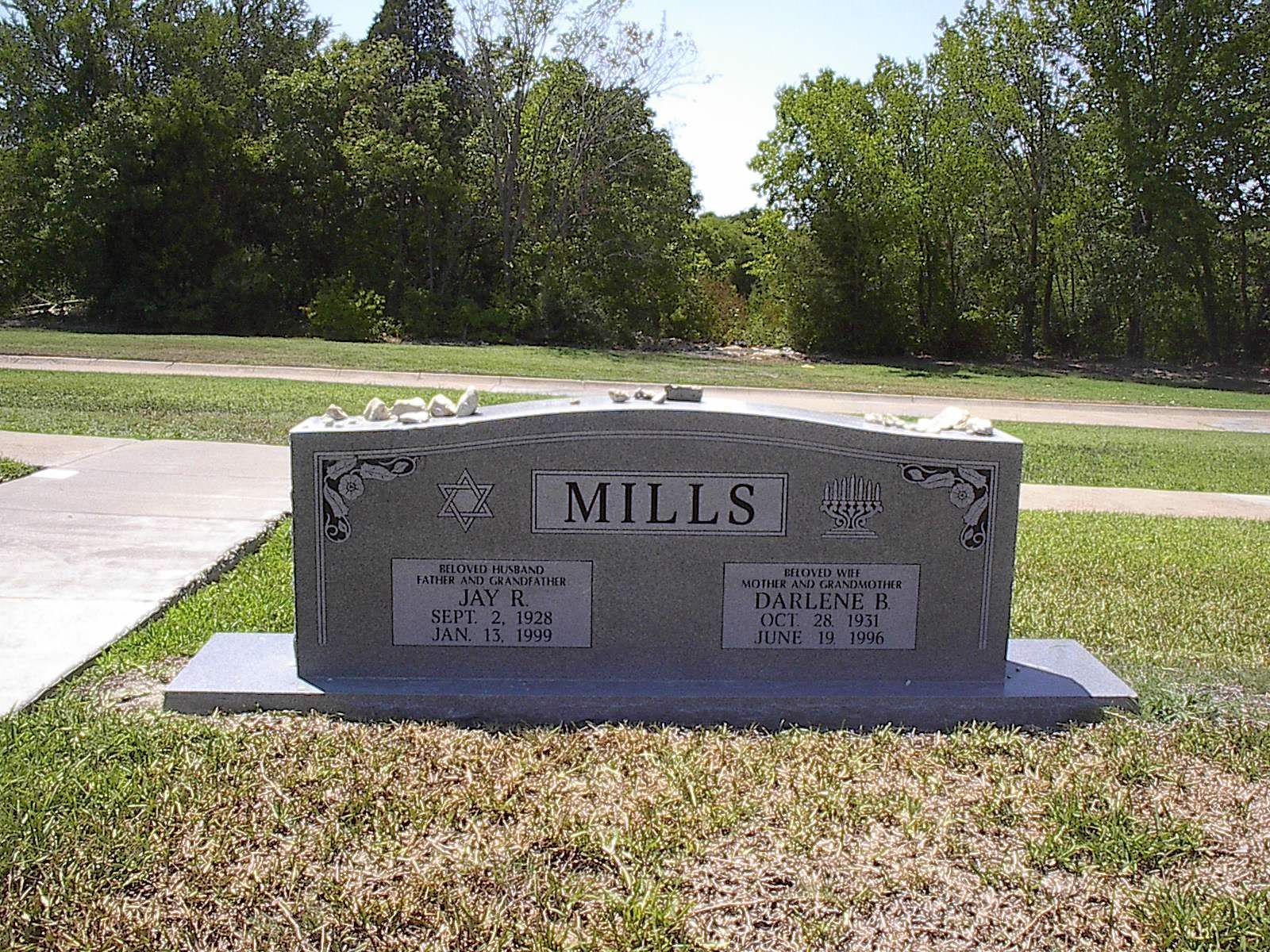 Gray stone headstone in a cemetery with the name