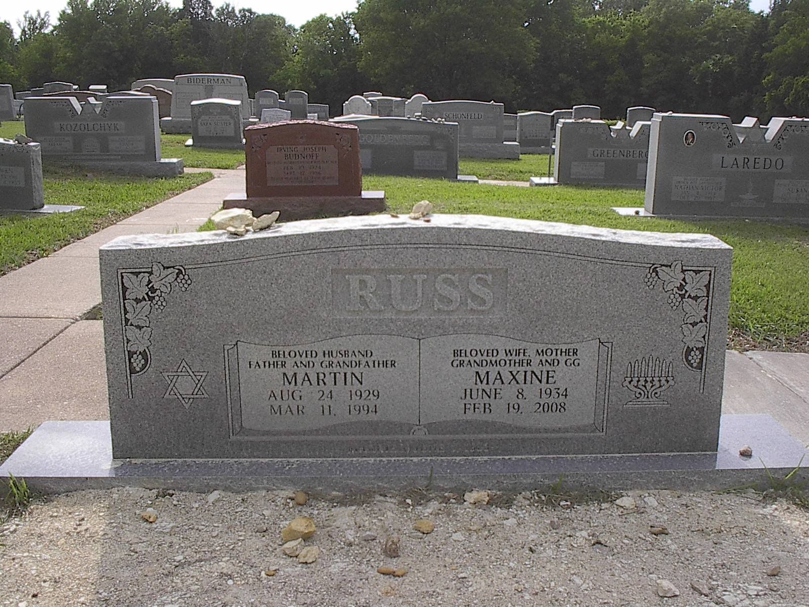 Gray headstone in a cemetery; reads