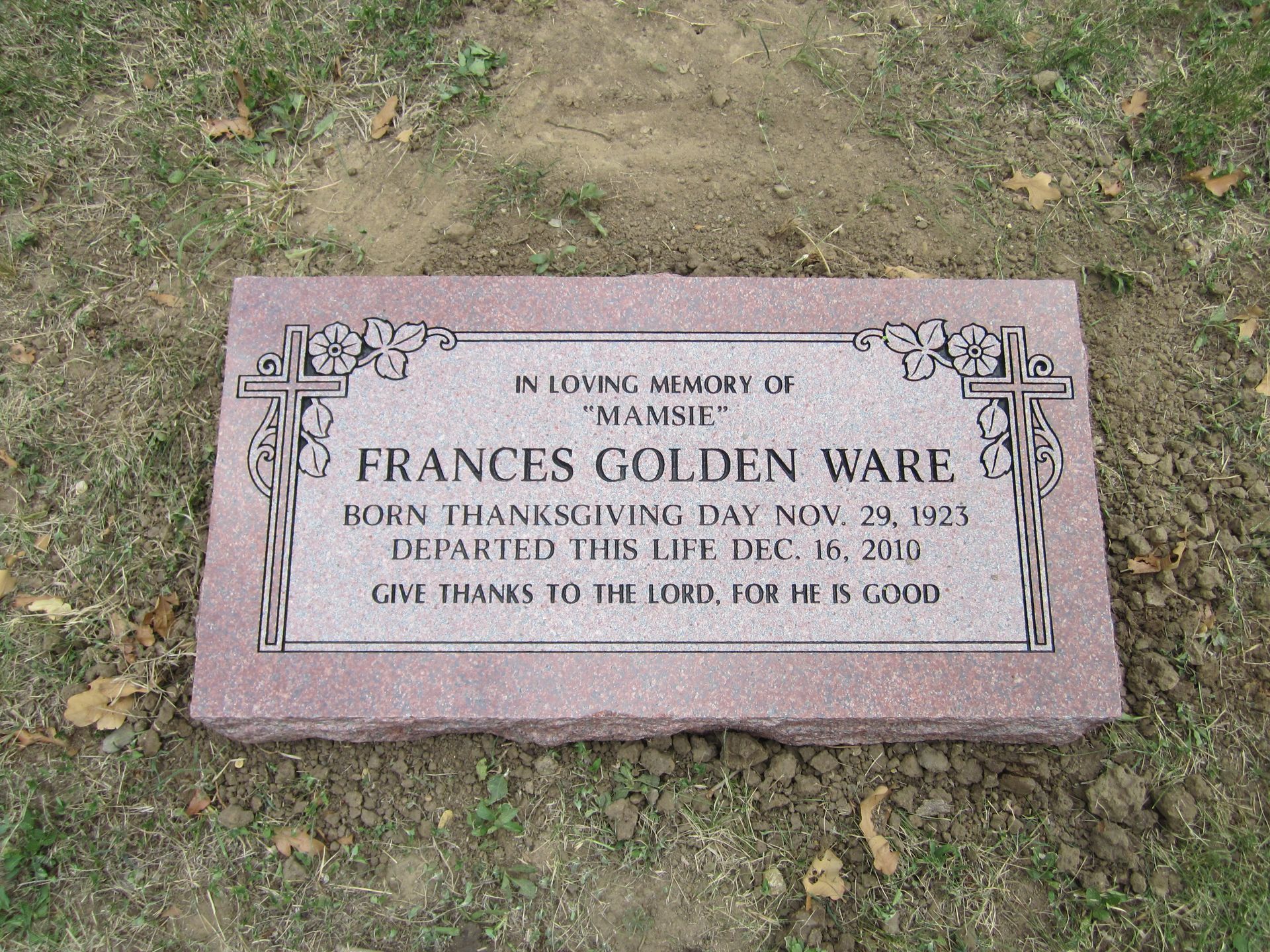 Pink granite tombstone of Frances Golden Ware, born Nov. 24, 1923, and died Dec. 16, 2013, with cross and floral designs.