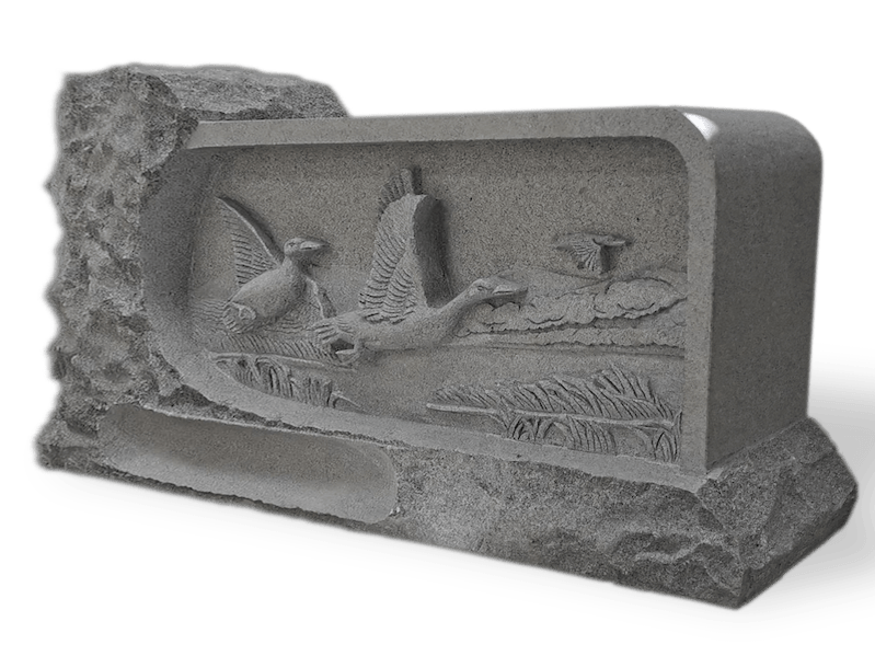 Gray granite tombstone with carved ducks and cattails.