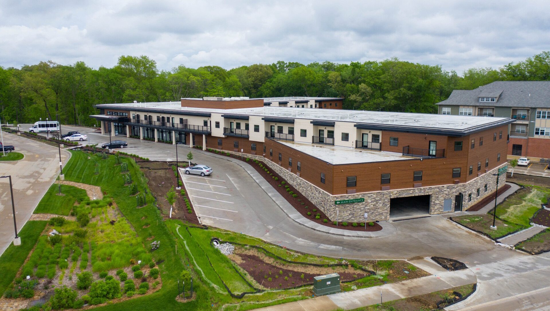 An aerial view of a large building with a lot of cars parked in front of it.