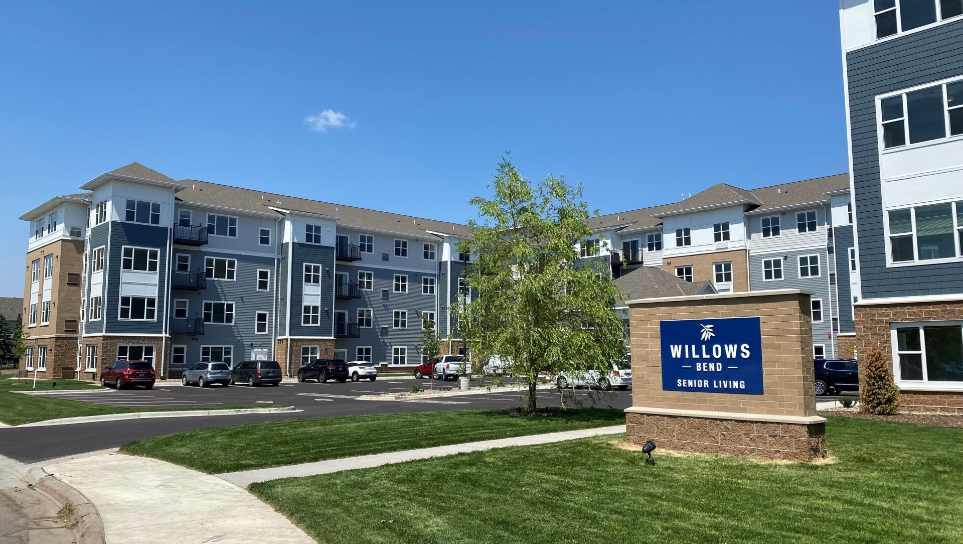 A large apartment building with a sign in front of it.