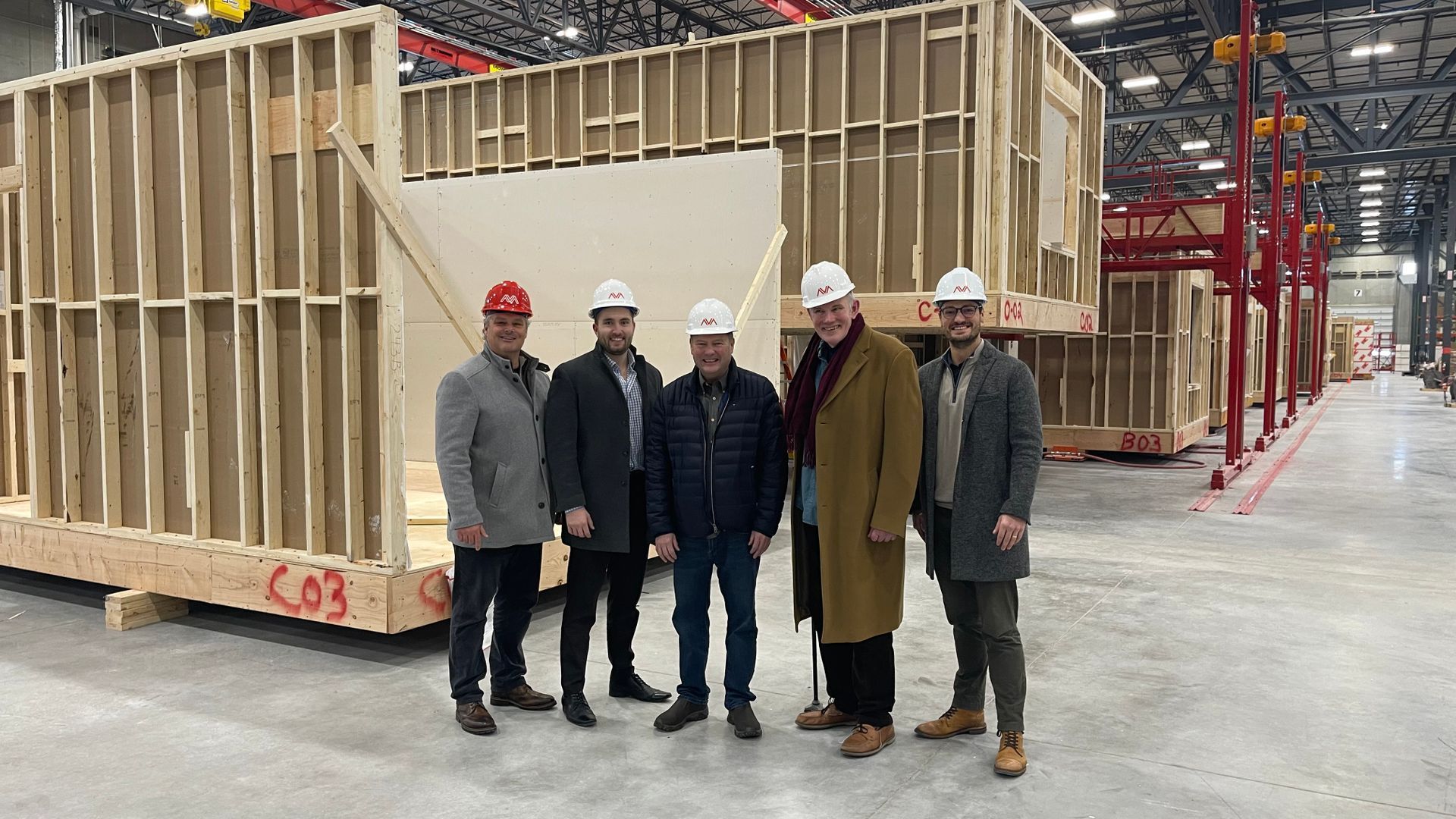 A group of men are standing in front of a building under construction.