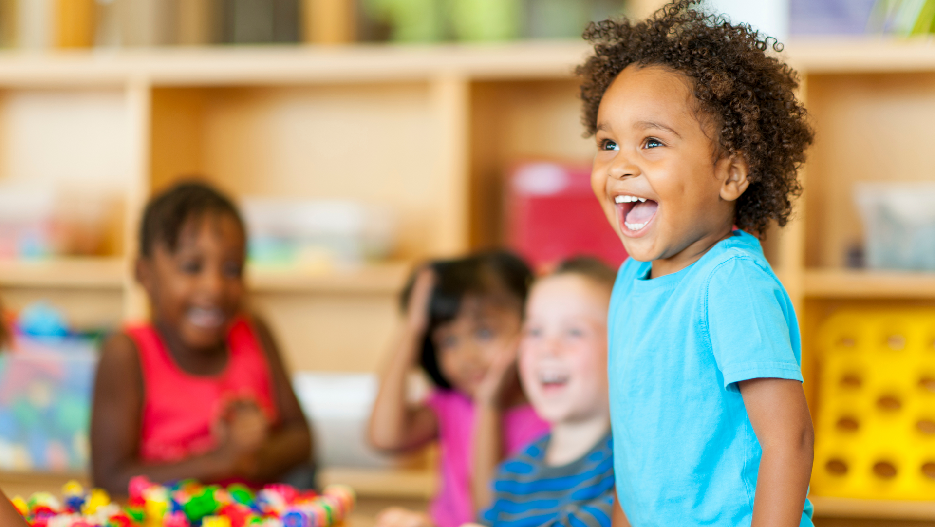A group of children are playing with lego blocks in a classroom.