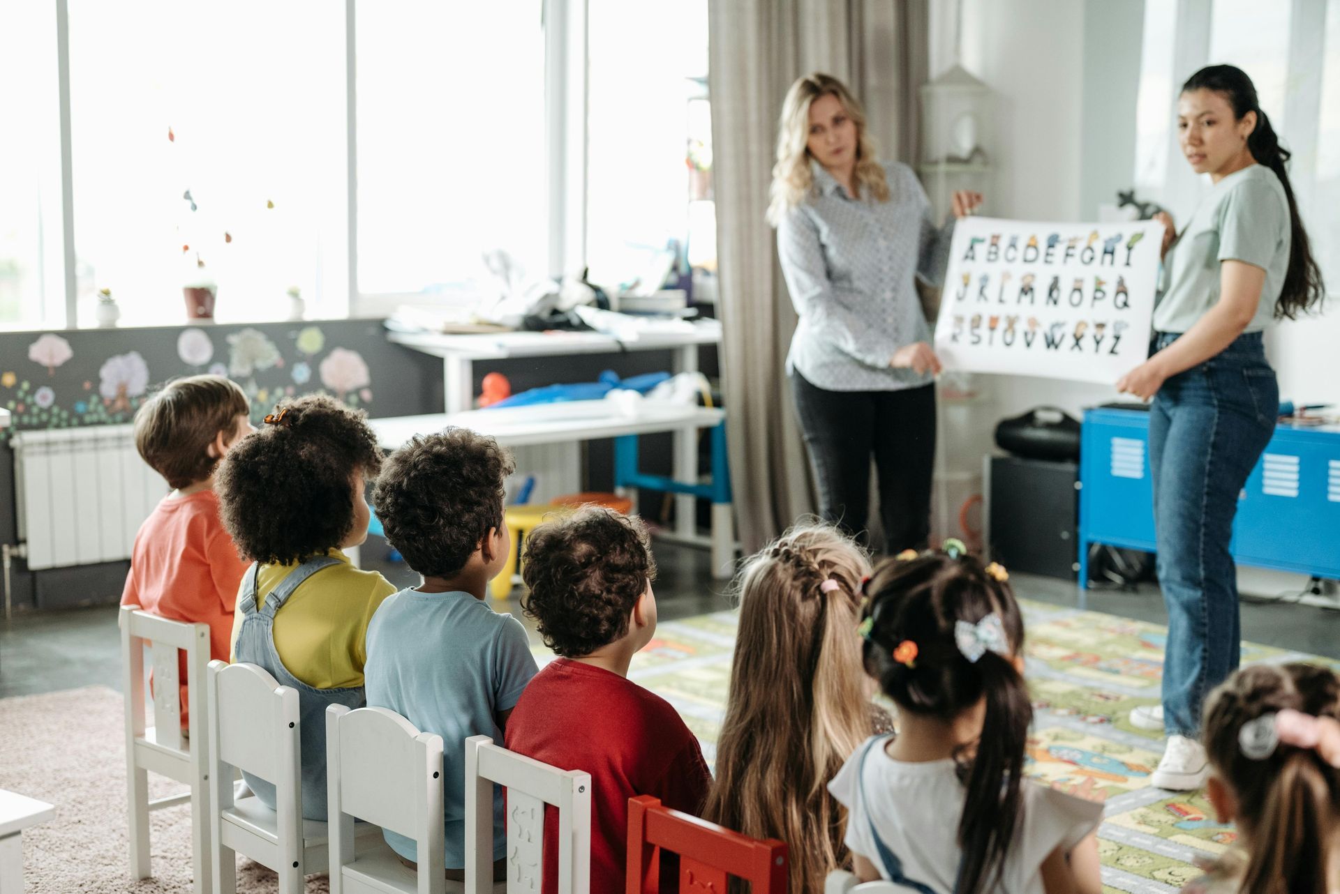 A teacher is teaching a group of children in a classroom.