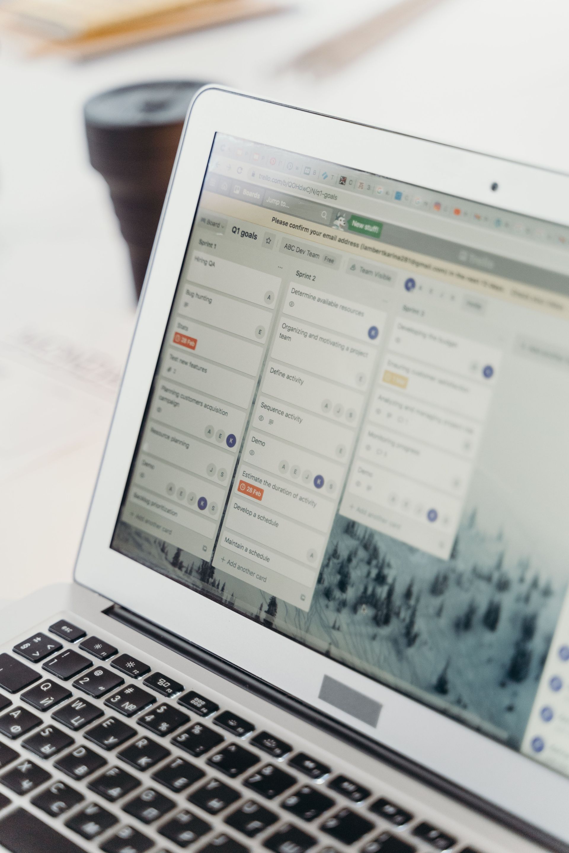 Laptop showing a scheduling app, with a blurred coffee cup in the background