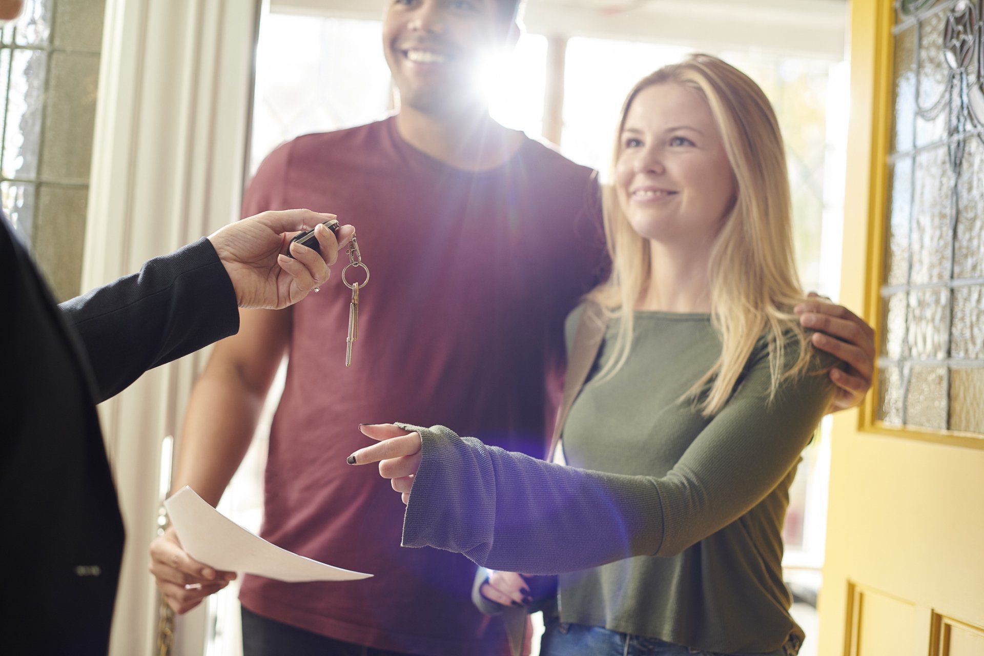 man and woman receiving key from realtor
