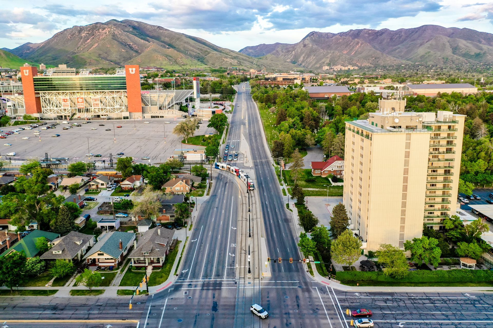 Aerial view of a wide city street with mountains in the background and buildings on both sides.