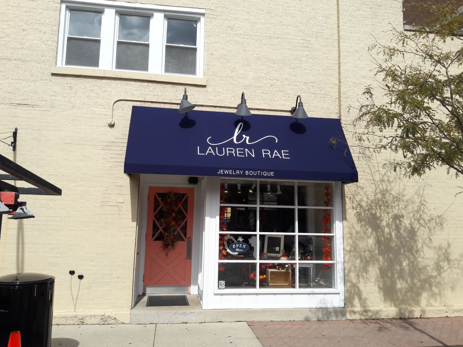 A store front with a blue awning that says lauren rae