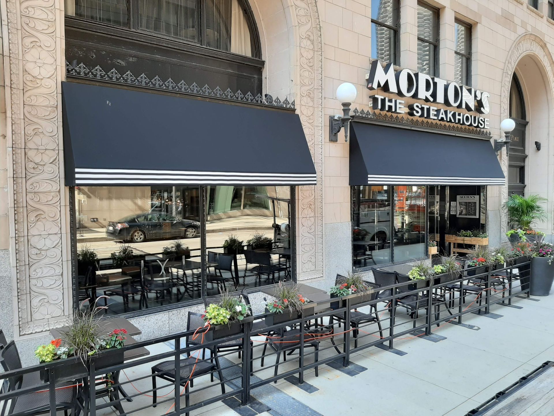 A restaurant with tables and chairs outside of it.