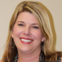 A woman with blonde hair and red lips is smiling for the camera.