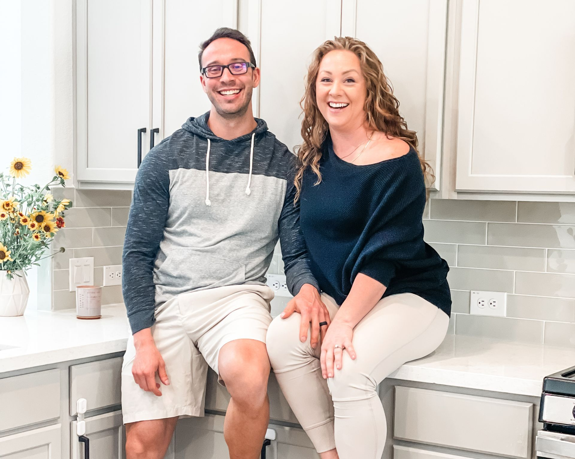 Amanda and Peter AP Digital Service Founders Sitting On Counter Smiling