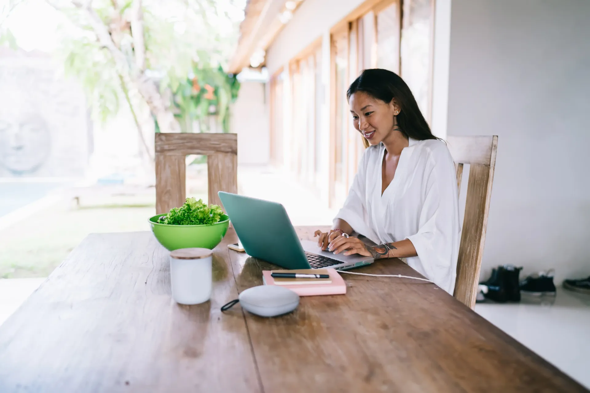 A woman is sitting at a table using a laptop computer.
