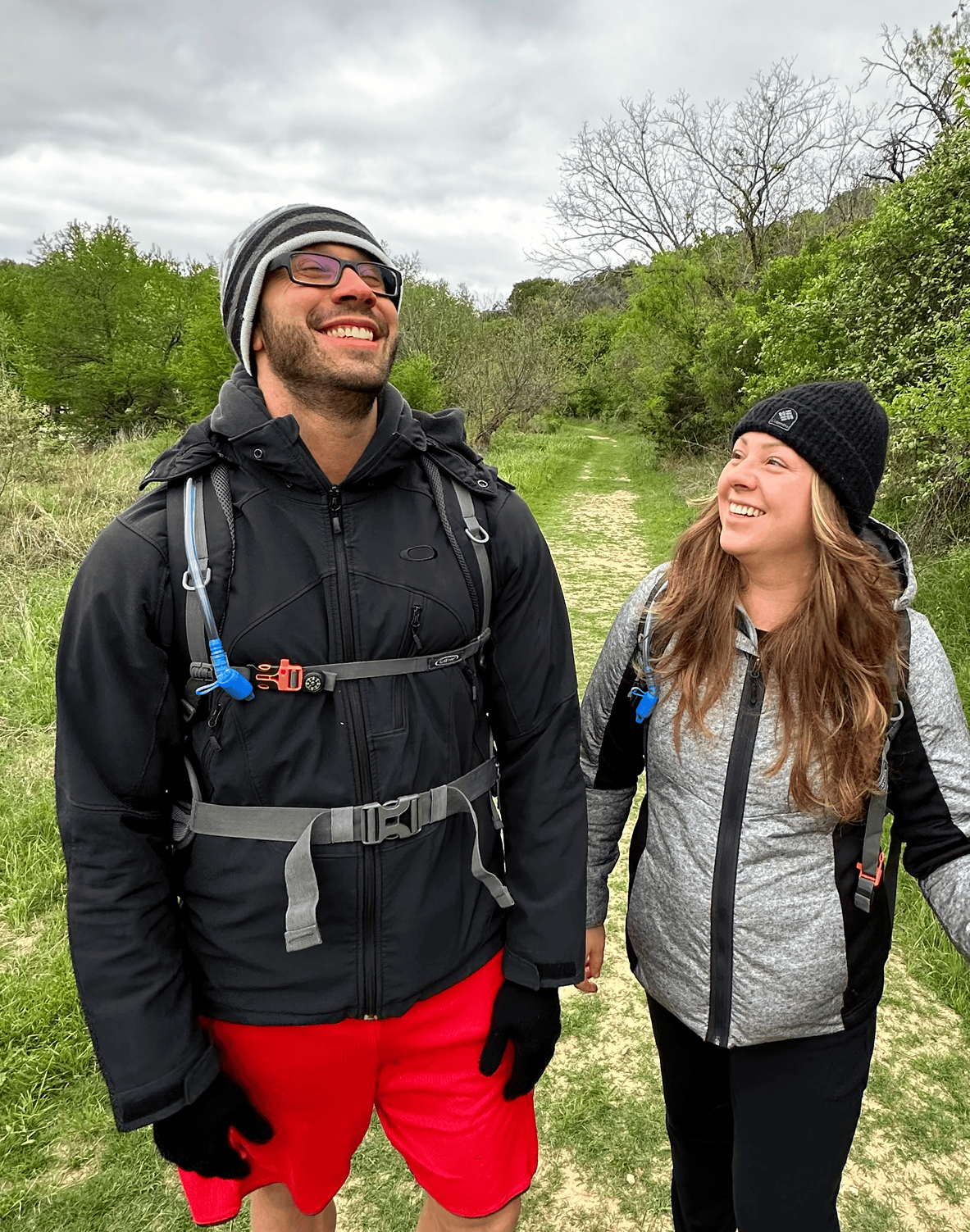 A man and a woman are standing next to each other on a trail.