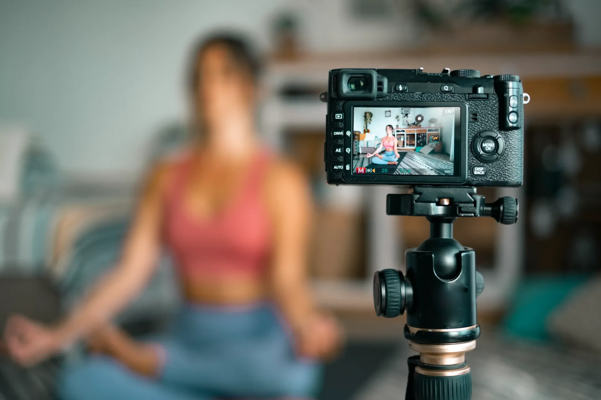 A woman is sitting in a lotus position in front of a camera creating content for her SEO website.