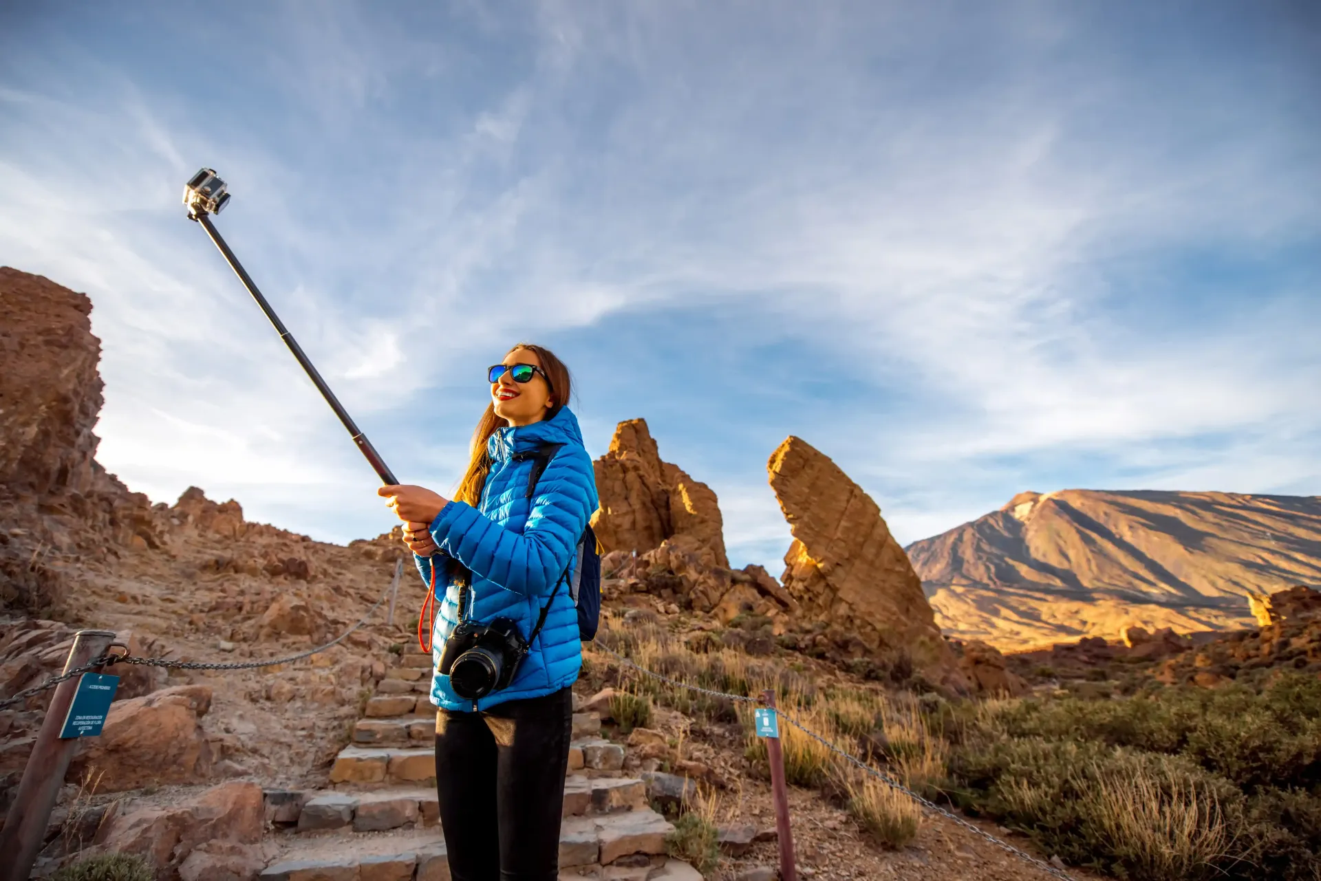 A woman is taking a selfie with a tripod  making content for her coaching business.