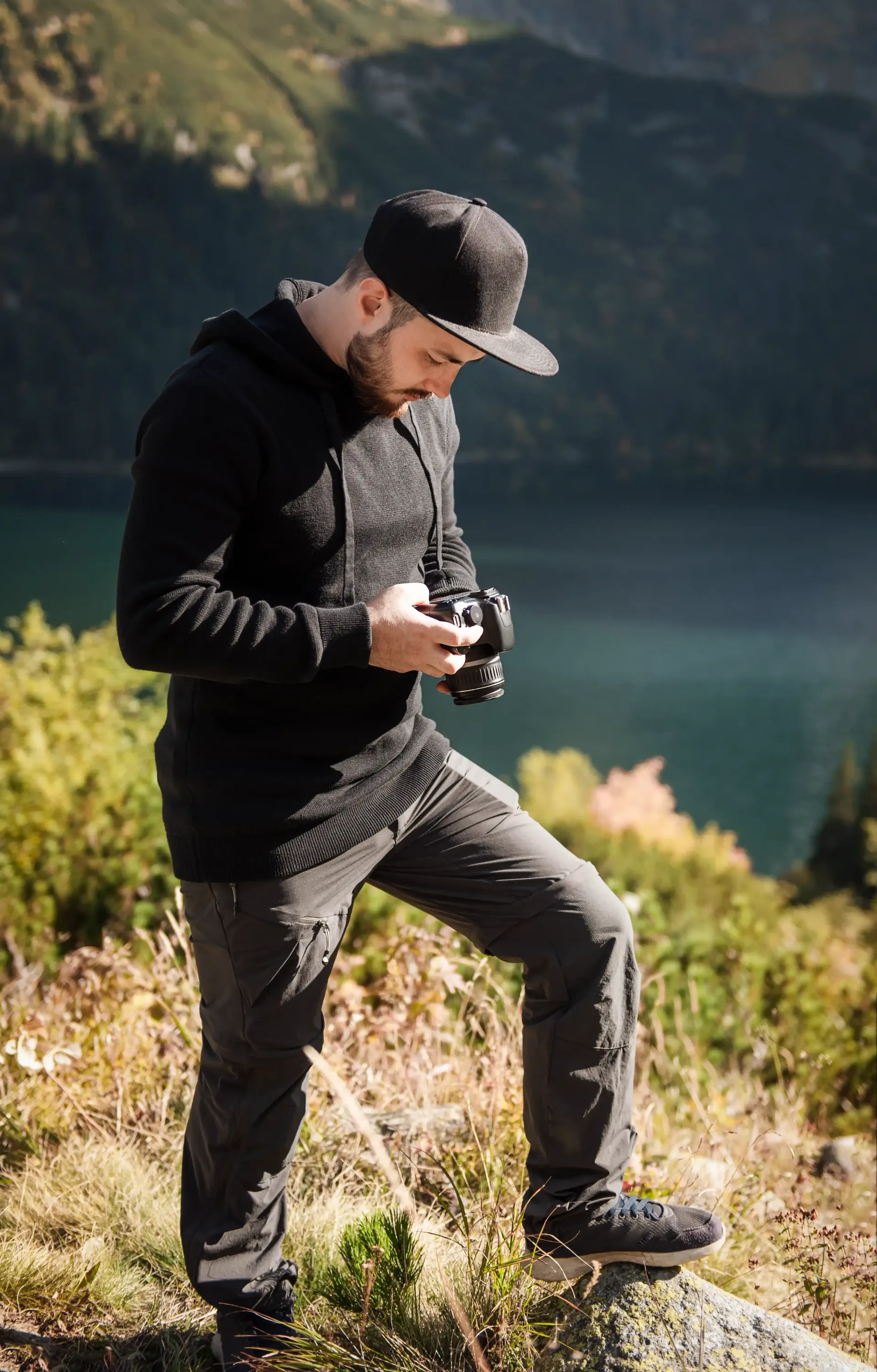 A man is standing on a rock collecting content for his coaching business for his SEO website.