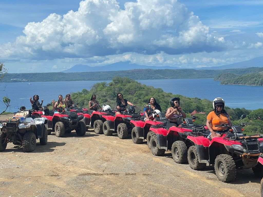 A group of people are riding atvs on a dirt road.
