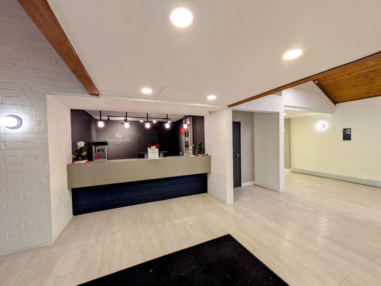 A hotel lobby with a reception desk and a black rug