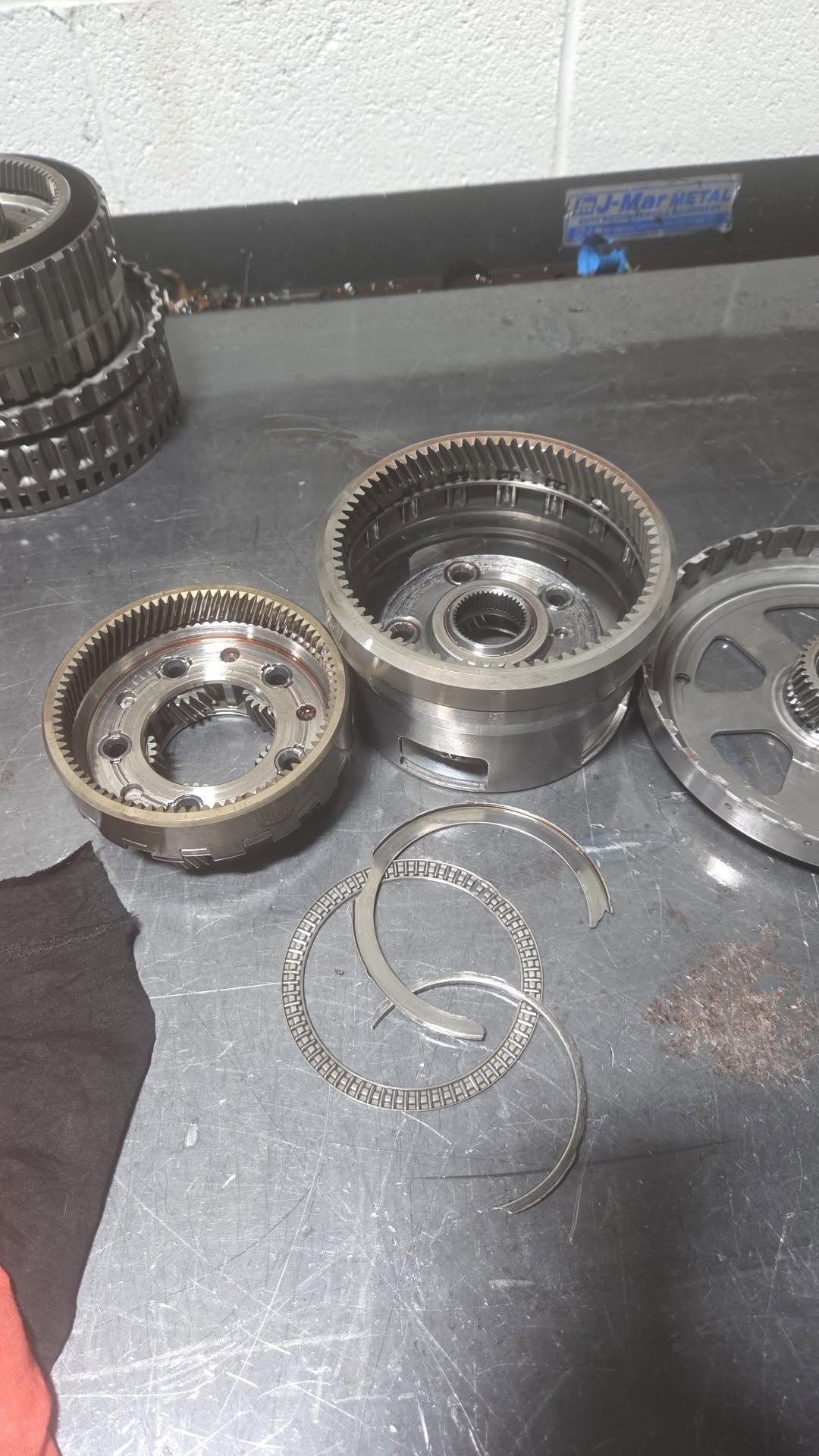 Disassembled metal mechanical parts and springs on a dark workbench.