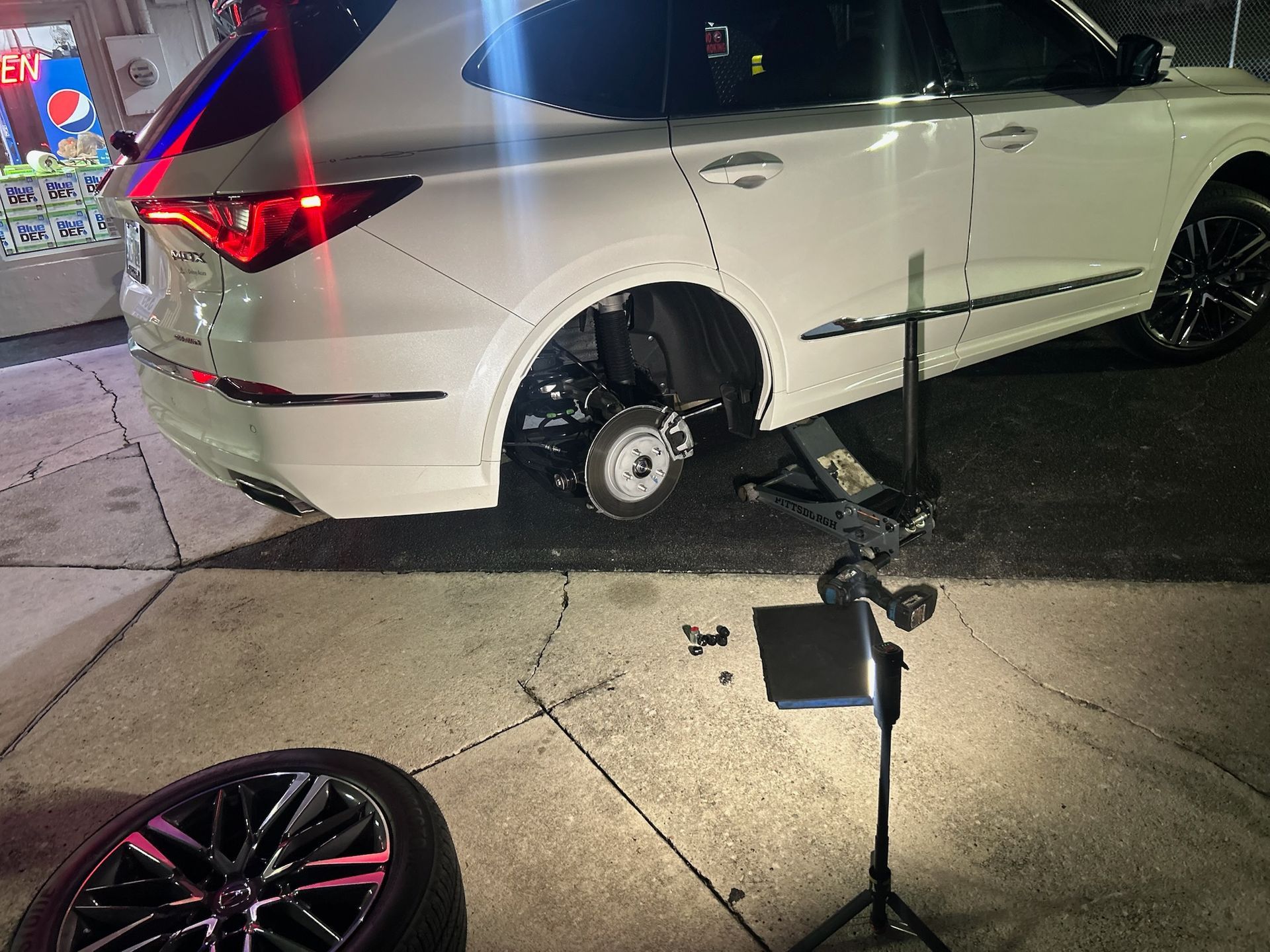 Mobile tire technician performing roadside tire service at night in Lauderhill, Florida