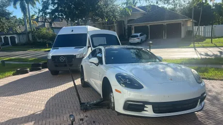 Mobile tire service van parked beside a car at a residential property