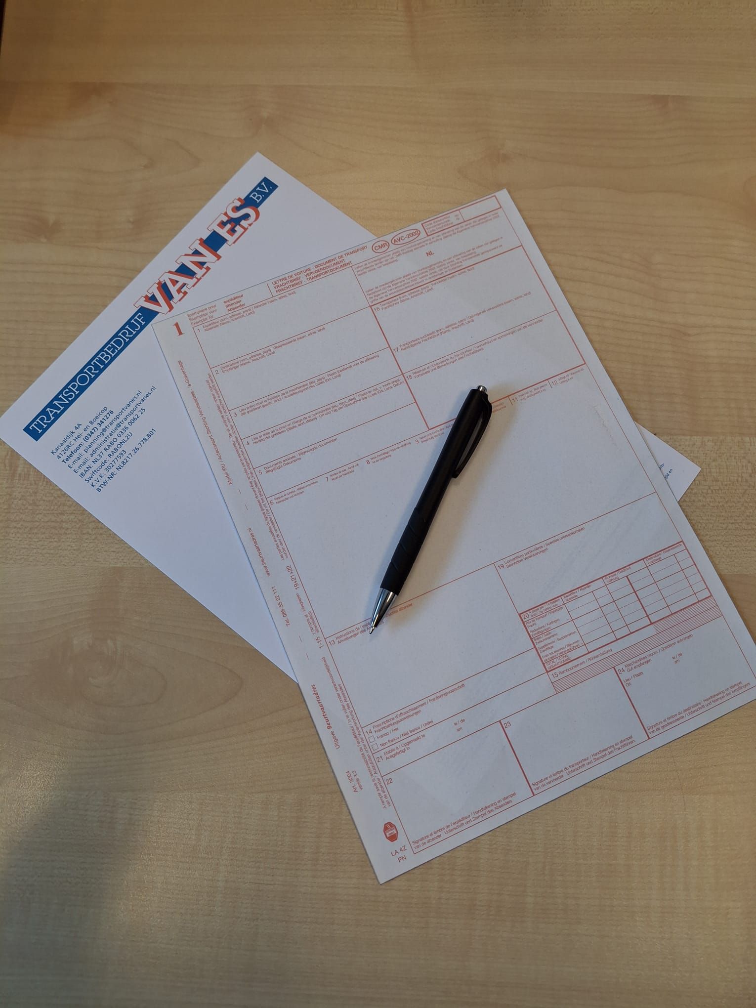 Formulieren en een zwarte pen op een houten bureau.